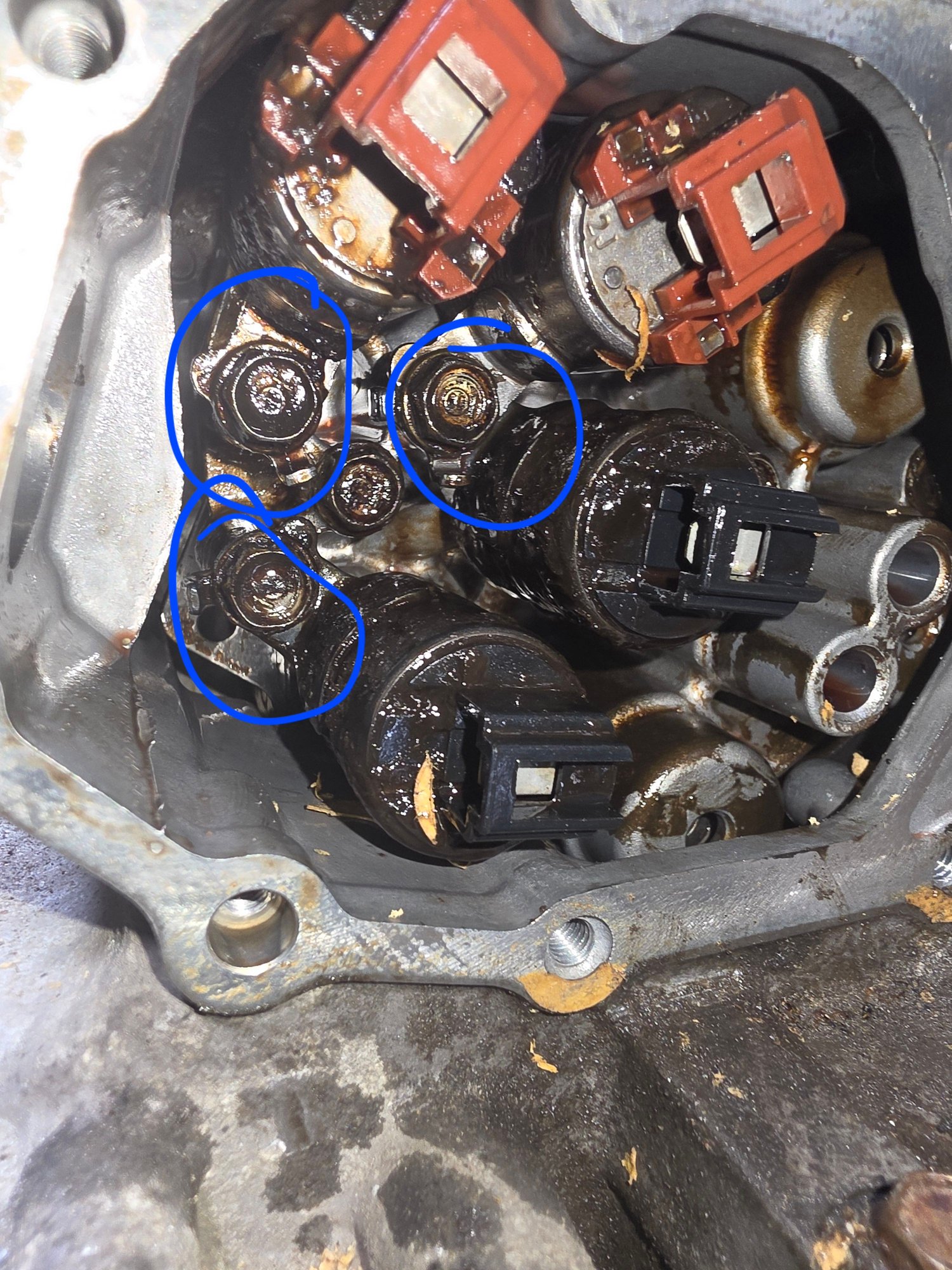 Remove only the bolts circled here the top right bolt holds two solenoids together. 