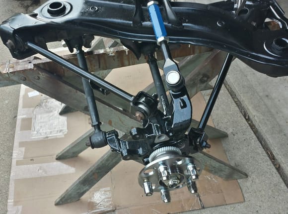 Mounting suspension knuckles on rear subframe. Adjustable control arms were preset to stock length before installation. Lower rear control arm must be connected first.