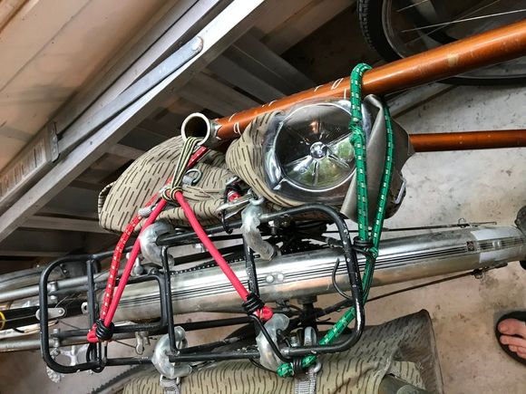 Close up of my not so tidy bungee job. I used an empty water bottle as a frame bumper. Kept it away from the wheels and the derailleur. 