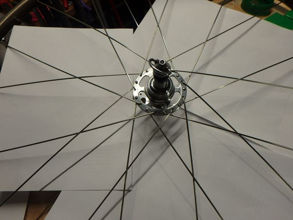 I have placed a few sheets of paper inside the wheel to make the spoke pattern show up better.  The pattern with the nine pointed star around the hub indicates that the build is going correctly. 