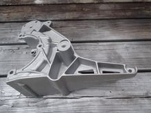 Accessory bracket from V8 that does not have the Air Pump provision. Freed up lower bolt hole to use as the engine ground.