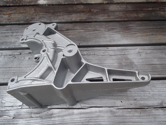 Accessory bracket from V8 that does not have the Air Pump provision. Freed up lower bolt hole to use as the engine ground.