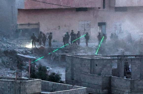 Israeli troops use laser beams near the family house of Diaa Hamarsha, a Palestinian who in March killed five people in a gun attack in the Orthodox Jewish city Bnei Brak, after blowing it up in the village of Yabad near the occupied West Bank
