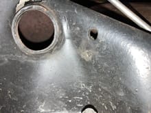 The small hole is where my original anti rattle spring ran from there to the clutch fork, my headers interfered the spring, so for awhile I used a shorter spring hooked to a radiator clamp on the header pipe.