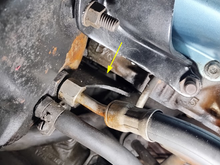 Manifold slips in between cylinder head and power steering pump bracket.