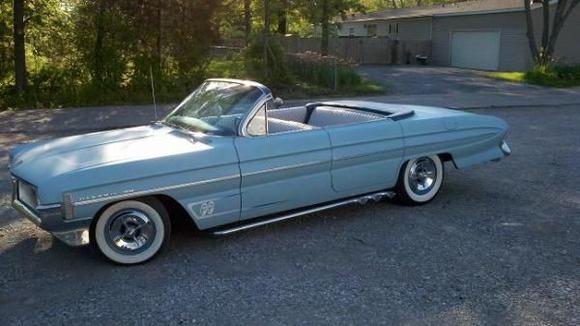 Powder blue primer with &quot;old school&quot; scallops on hood, fenders, and deck lid.  White wall tires, shaved door handles, shaved reverse lights.  Top was chopped after 2nd owner busted the rear windshield.  All body customizing done by a junior college body shop instructor.  Very little surface rust, very solid car.