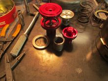Sonnax makes some pretty parts. Front piston on the left is completely re-engineered. All these parts come with improved seals.Accumulator piston on right was plastic from the factory. Wears out, leaks, causing line pressure leakage/problems. Supposedly can even stick or cock in the bore. Rear piston is hard to see, so no pretty red anodizing.