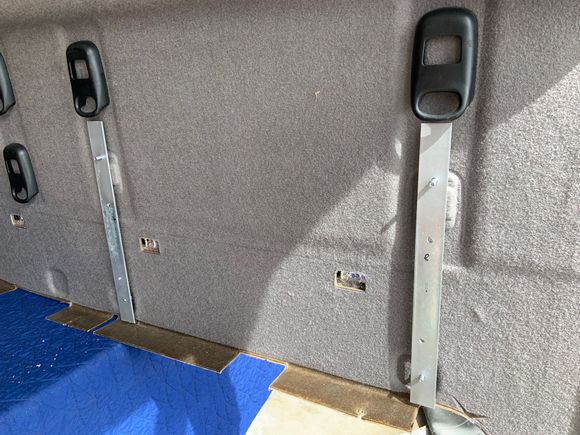 Some old galvanized metal strips lying around in the garage were used to secure the board to rear panel. 