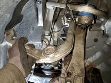 New upper control arm next to old one.