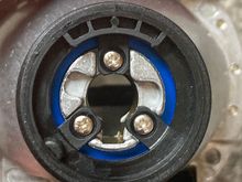 Here the Moto-Holder base is screwed onto the projector housing. Note the slot for the ground rod of the bulb to pass through. Also note the dimple at 7 or 8 o'clock to mate w/ the horseshoe clip.