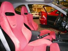 These Recaro seats are from a JDM EP3 Type R. These have the leg extenders. They are bolted in with Wedge Engineering rails and brackets.

Compared to the DC2 and DC5 Recaros, these are MUCH more comfortable for a street driven car and for long road trips.

The shift knob and e-brake handle are Momo.

The center console cover is covered in OEM suede and red stitching.