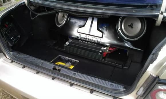 Sub Enclosure Fiberglass/MDF.
-Gloss Black.
-2.50 Cubic Feet.
-Raised JL AUDIO Logo Airbrushed In Silver.
-Blue Neons.
-250lb Force Tube Actuator/Motorized Amp Rack.
Trunk Floor
-3/4&quot; MDF Hinged False Floor.
-Covered In Black Vynil.
-3/4&quot; Plexiglas Window.
-Silver MAXED OUT Decal.
-FATMAT Sound Deadener.
Spare Tire Well
-OPTIMA Yellow Top Battery.
-TSUNAMI Titanium Battery Terminals.
-STINGER Circuit Breaker.
-2 10&quot; Blue Neons Illuminating Battery.
-2 JL AUDIO 10w1v2 10&quot; Subwoofers/Silver Trim Ring.
-Black Dyed Trunk Panels.
-IMPULSE Blue 18&quot; Blue Neon Accent Tube/Trunk.
-2 MOBILE Blue 18&quot; Blue Neon Accent Tubes/Trunk.
-HIFONICS ZEUS 5 Channel Amp (Subwoofer/Mids/Highs).