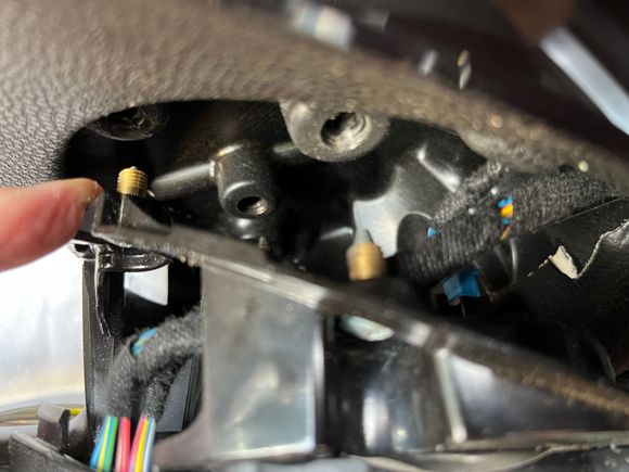 Finger pointing to one of the two fasteners that have pulled free