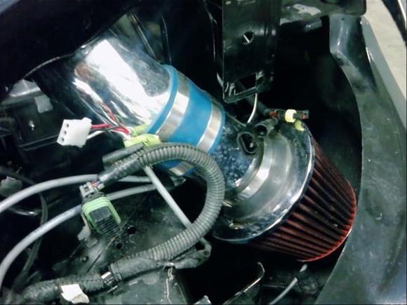 my intake closeup. sits nicely down in the bumper. Ofcourse i had to get a pcm tray kit to be able to fit the piping through where the enormously large airbox used to be.