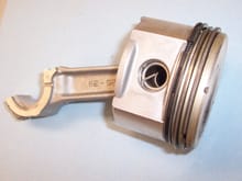 Piston, rings, and rod from a Briggs and Stratton 28cid OHV air cooled engine. Note the construction of the oil control ring.