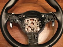 After removing trim, the paddle shifter hardware can be seen. Two 7mm nuts hold the paddle assemblies to the wheel.