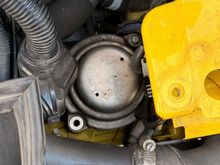 View of the mount from the top. First jack up the engine (just support it), use a sturdy piece of wood to not stress the plastic oil pan.
Then remove the bottom 18mm nut, and the two e17 (I believe) screws. The mount can be removed without removing anything else but it is a PITA. the housing seen on the lef of this picture is interfering. See the difference in size below:

