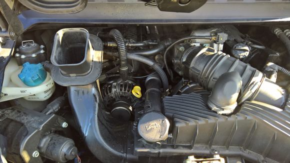 A very wet and dirty engine with coolant all over it.