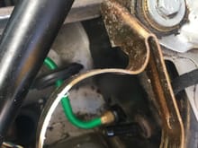 You want this gold bracket out, you can see the grommet on the green pressure hose and the black nipple for the reservoir feed.