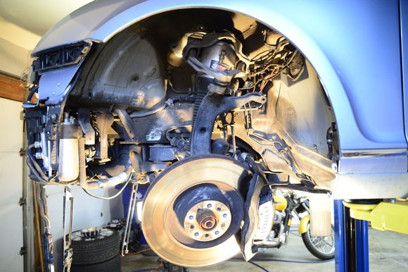Now to removing the front suspension. I opted to keep the airshocks still connected to the engine. Removing the top shock tower, steering rack, and brake calipers. Do not disconnect the hoses to the calipers, just hang the attached to the body using coat hangers