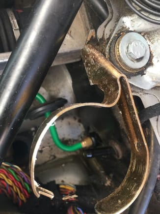 You want this gold bracket out, you can see the grommet on the green pressure hose and the black nipple for the reservoir feed.