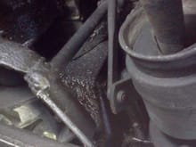 This photo shows a vertical rod welded to part of the transmission crossmember.
