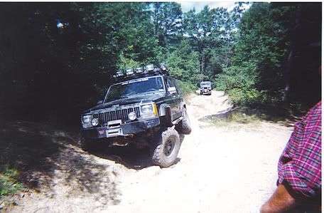 Cherokee in washout with willys following