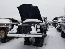 It seems like some kind of 1959–1968 Mercedes W111. This one is especially dreadful to see at the junkyard, even in this condition, it is still worth restoring, since it is extraordinary rare, and it still has its engine and interior remnants in place...