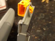 Extracted rear view mirror.  Orange electrical connector depicting compression wings which just hangs over the side without a compression base.