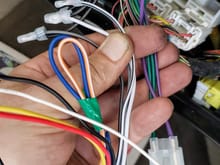 This shows the two female sockets of the Metra 70-1761 harness.  The black wires (running from the Head Unit) are shown connected to the color-coded speaker wires of the Metra 70-1761 harness using crimp caps.   