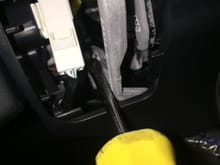 Upon removal of the two side covers, you'll see these spring pins on each side, push them slightly with a screwdriver and you'll notice the horn pad/airbag assembly pop away from the steering wheel, it is held in three positions.