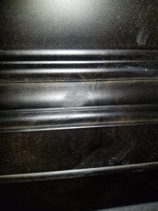 Fingerprint or rag-mark from the staining process, its rough as hell and catches dirt and dust.  Its impossible to clean.