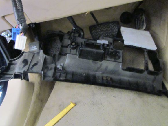 this bottom trim will come off with two screws . the passenger side will be able to pry downwards and the ambient led light will be able to be un plugged also on the drivers side the DLC connector will be able to pop out