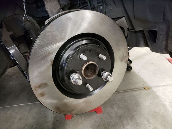 New rotor installed. Use two lug nuts to snug the rotor onto the hub. This will prevent interference while trying to install the caliper and pads.