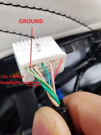 The white wire with black stripe is Ground.