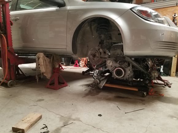 Have the engine under the car ready to try and line everything up with an air lift on one side and two floor jacks on the other side. It will be a very slow process but should work.