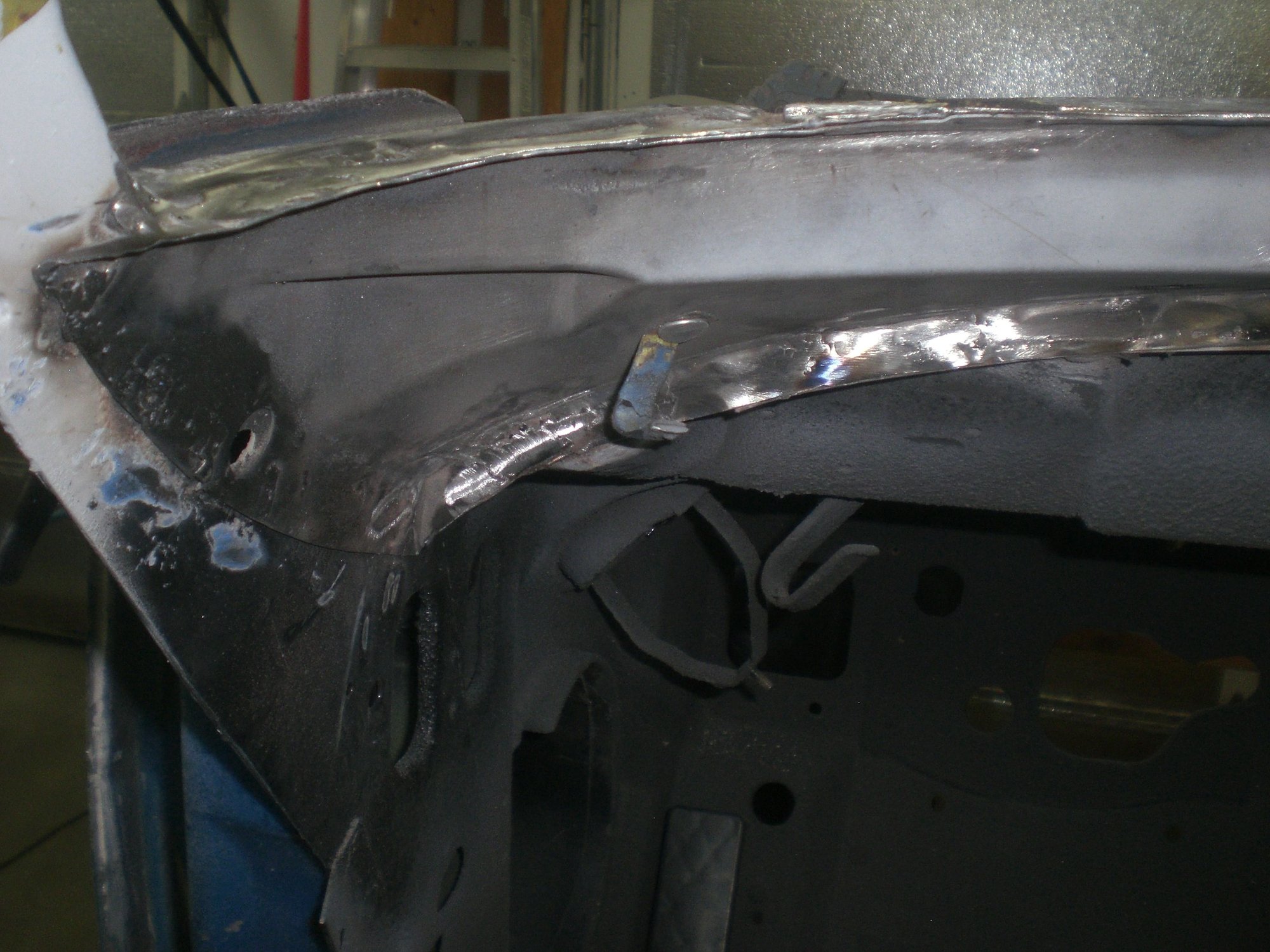 Onve outer corner was welded back in, inner corner only provides support - no glass mating surfaces.  Alignment of access holes in both the hinge pillar and inner corner provided positioning cues.