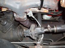 Cable bolted to exhaust manifold bolt hanging loose.