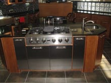 stove top with aluminum cabinets below for pots and spice drawers on each side