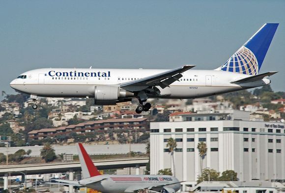 B767-200 ('baby' Big One) landing at San Diego. Terrain in background above aircraft.  The standard 3 degree glideslope is NOT used due to obstructions, etc.