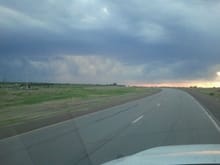 Driving down a KS highway while thunderstorms are building at sunset.