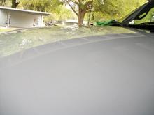 reflection of the carport roof across the hood