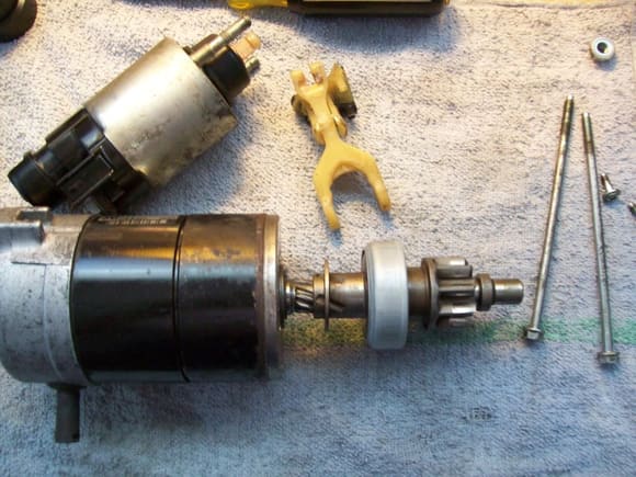 Solenoid is pivoted away and fork is removed. due to the, well, innovative braided wire between solenoid terminal and starter "yoke" Honda calls the stator housing) I kept these two items together