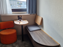 The seating area was perfect to do some laptop work. The window could open (not fully). With the window closed you didn't hear any street noise at all. At the desk a chocolate brownie+berries and a personalized welcome card was greeting me. There's a 0.5 litre bottle of mineral water, I expect it to be in every room, that's rather customary in Germany. The TV had an awful sound quality. There's no fridge in the room, but there is a safe, though it didn't appear to be attached to anything. 