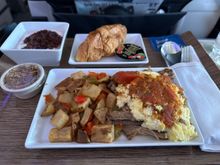 Pulled pork breakfast scramble - pork carnitas, scrambled eggs, peppers and onions, potatoes, salsa. Served with croissant, yogurt and granola.