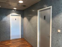 Past the toilet block,
The lounge has no own restrooms so you'll be using these