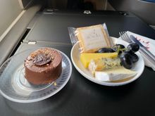 When the F/A came by after the meal service to ask if she could get me anything, I asked if they had any extra cheese plates or chocolate cake (tart?) left.  They did!