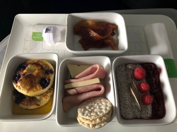 Clockwise from top: maple glazed bacon, vanilla coconut chia seed pudding, cheese & charcuterie, and blueberry banana pancakes