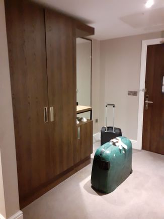 The entrance hall ) bathroom to right). Nespresso machine on top shelf.  Kettle with tea/coffee on shelf in cupboard ( also safe in cupboard)