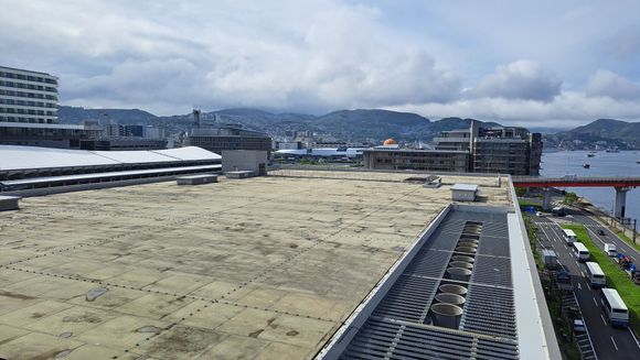 Couple of days later, it was raining when I woke up but was clearing rappidly. View of the roof of Dejima messe, the JR Station and part of the Marriott hotel on the left. The rear of a cruise ship docking can just be seen.